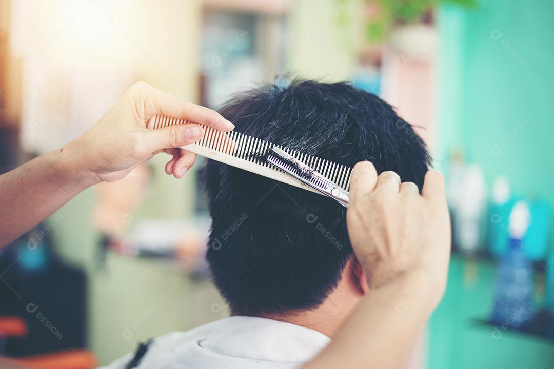 um homem cortando cabelo no barbeiro