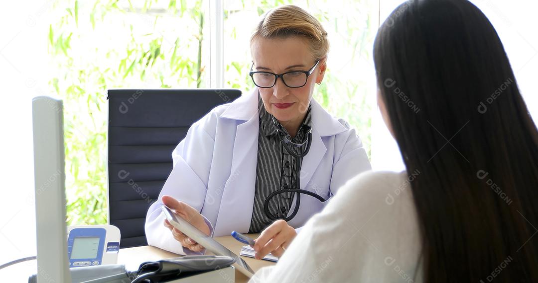 Médico reunido e explicando medicação para paciente mulher em seu escritório em hospitais