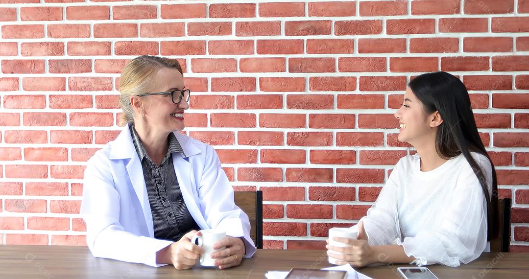 Os médicos estão bebendo café e sorrindo e rindo felizes na hora do intervalo.