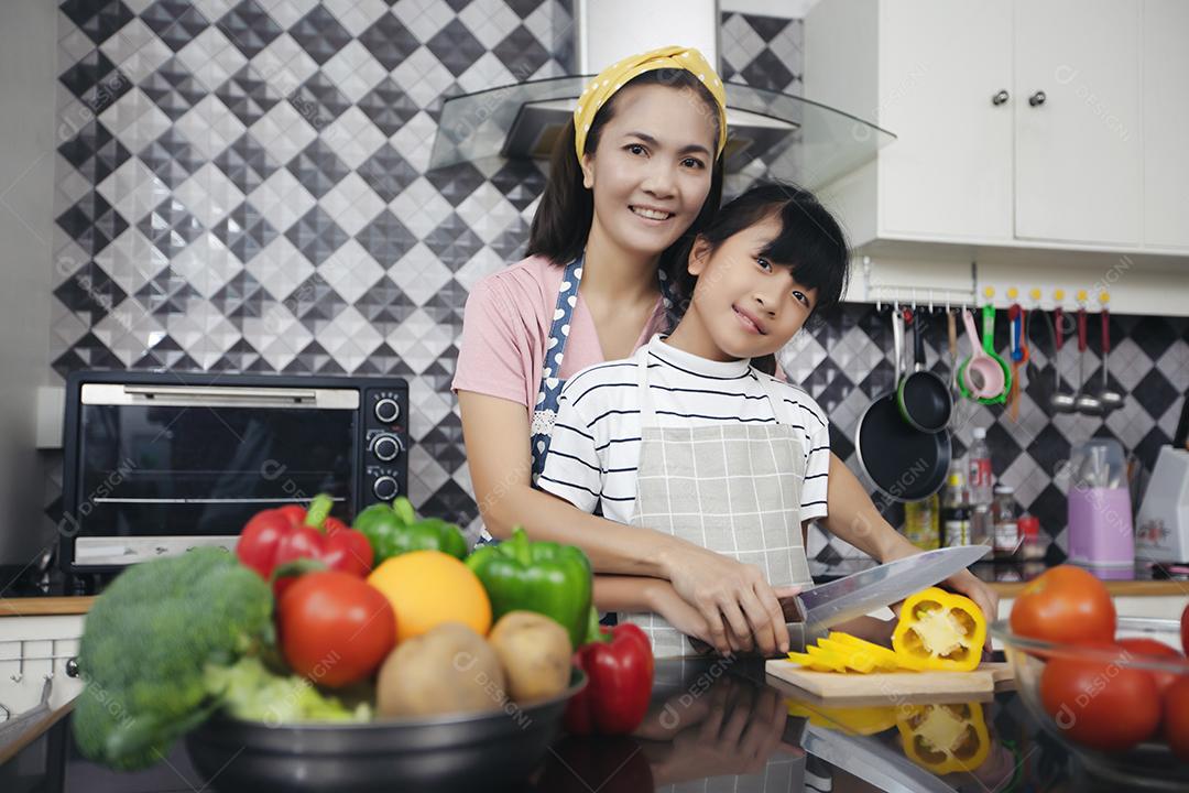 Família feliz tem papai, mamãe e sua filhinha cozinhando juntos na cozinha