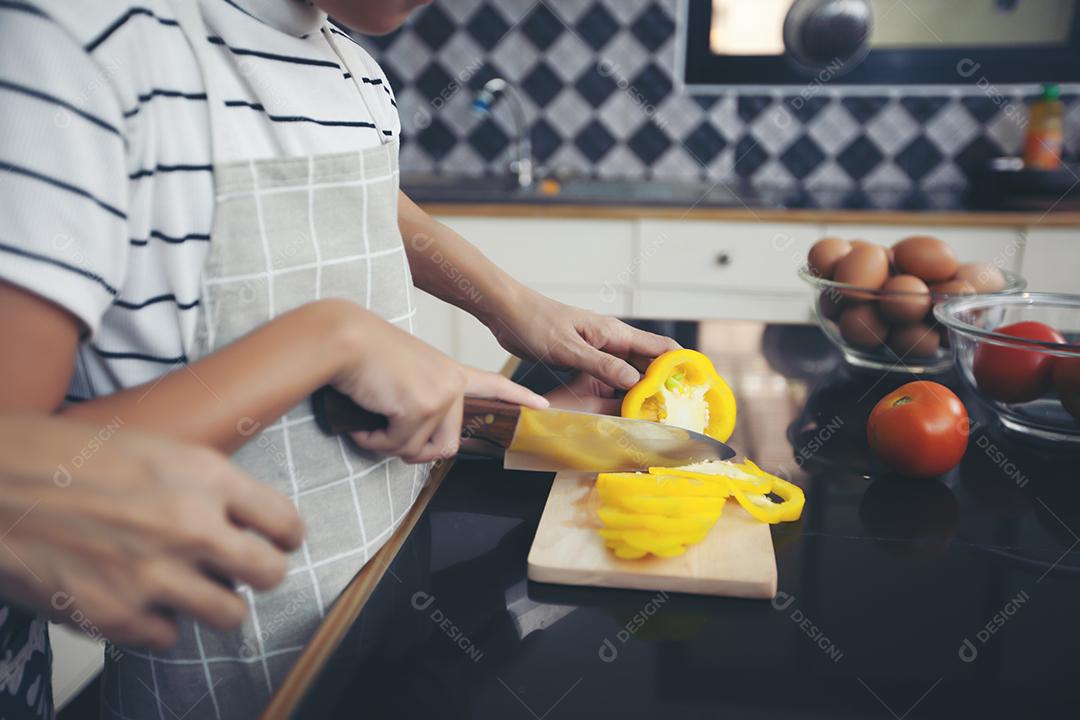 Família feliz tem papai, mamãe e sua filhinha cozinhando juntos na cozinha