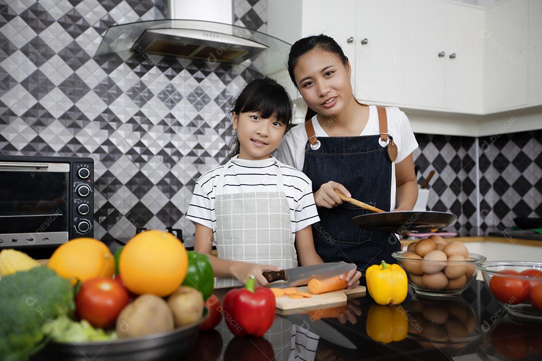 Família feliz tem papai, mamãe e sua filhinha cozinhando juntos na cozinha