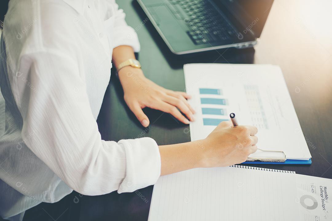 Mulheres de negócios asiáticos trabalhando e analisando gráficos no escritório