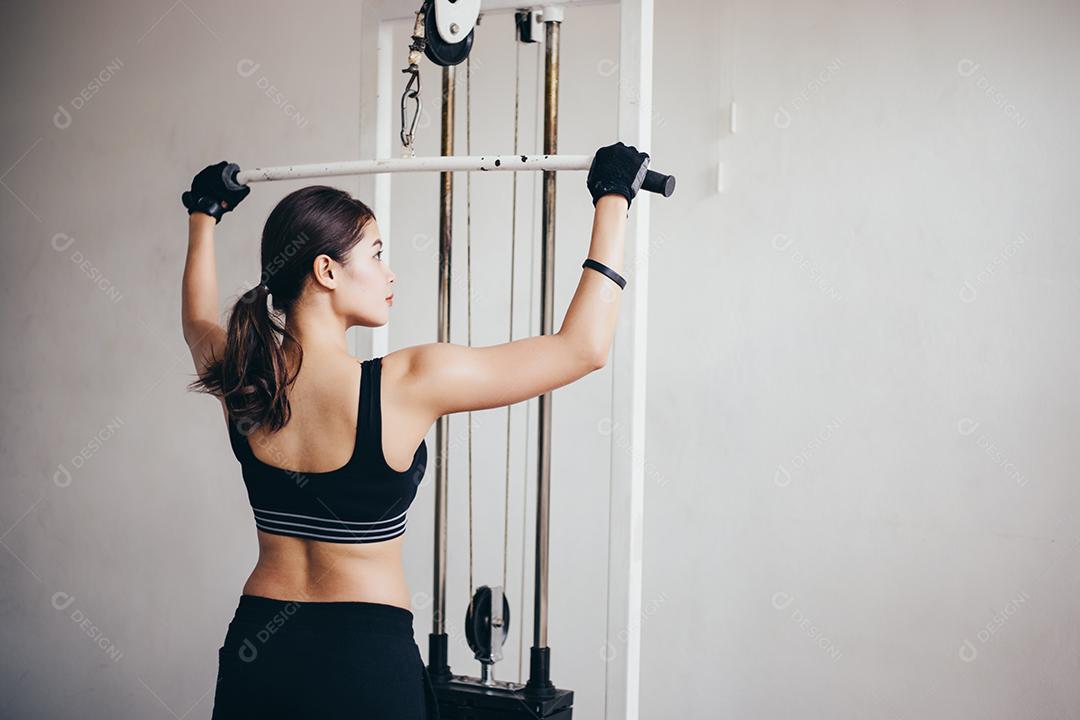 bela mulher apto muscular exercitando a construção de músculos e fitness mulher fazendo exercícios no ginásio. Aptidão - conceito de estilo de vida saudável