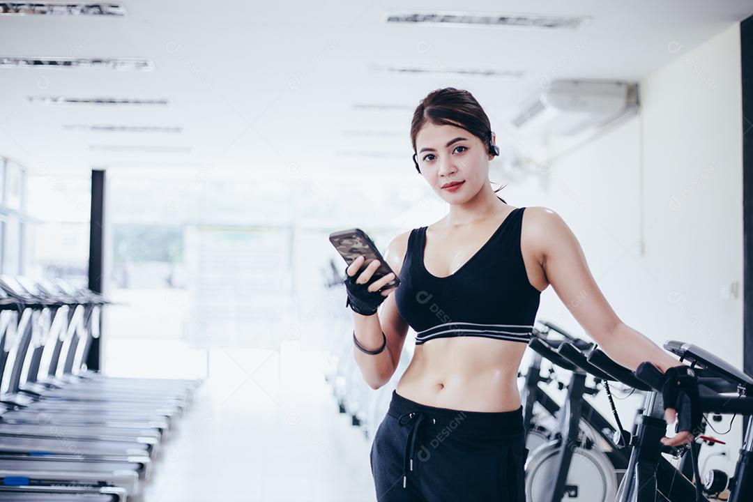 Atleta asiático em roupas de moda esportiva. Desportista ouvindo música usando aplicativo de telefone para rastreador de atividade física - monitor de frequência cardíaca rastreando seu progresso de saúde no smartphone.