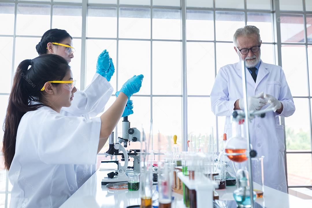 Pesquisa médica e cientistas estão trabalhando com um microscópio e um tablet e tubos de ensaio, micropipeta e resultados de análise em um laboratório.