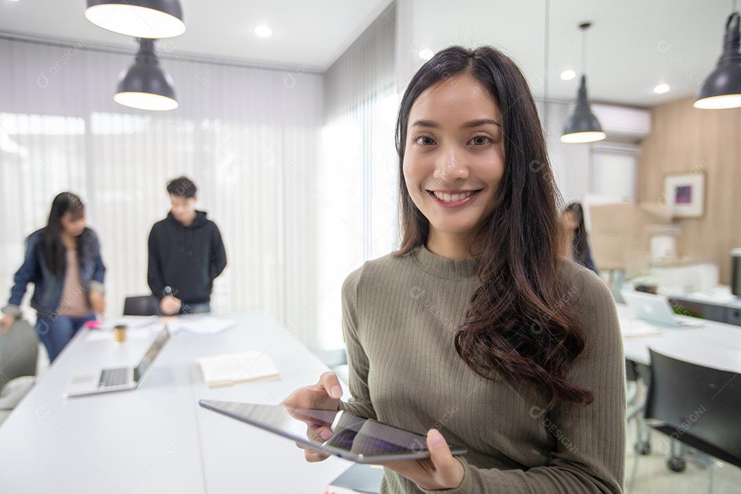 Mulheres asiáticas Estudantes Sorriam e se divertem usando smartphone e tablet Também ajuda a compartilhar ideias no trabalho e no projeto.