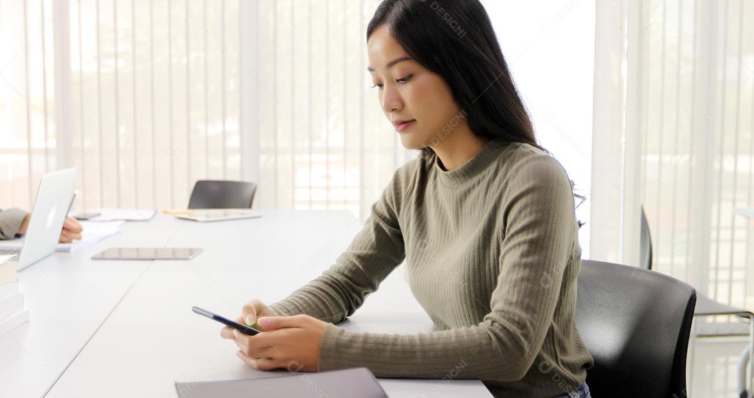 Mulher asiática Estudante Sorriam e se divertem usando smartphone e tablet Também ajuda a compartilhar ideias no trabalho e no projeto.