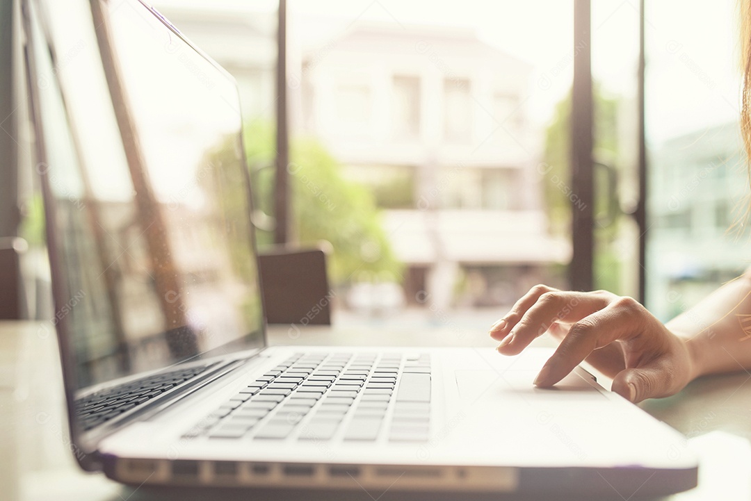 Cortada a imagem de uma mulher trabalhando em um laptop