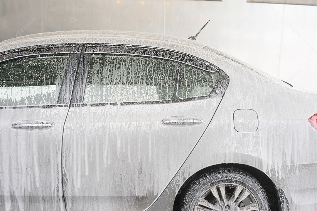 Mão segure a esponja sobre o carro para lavar