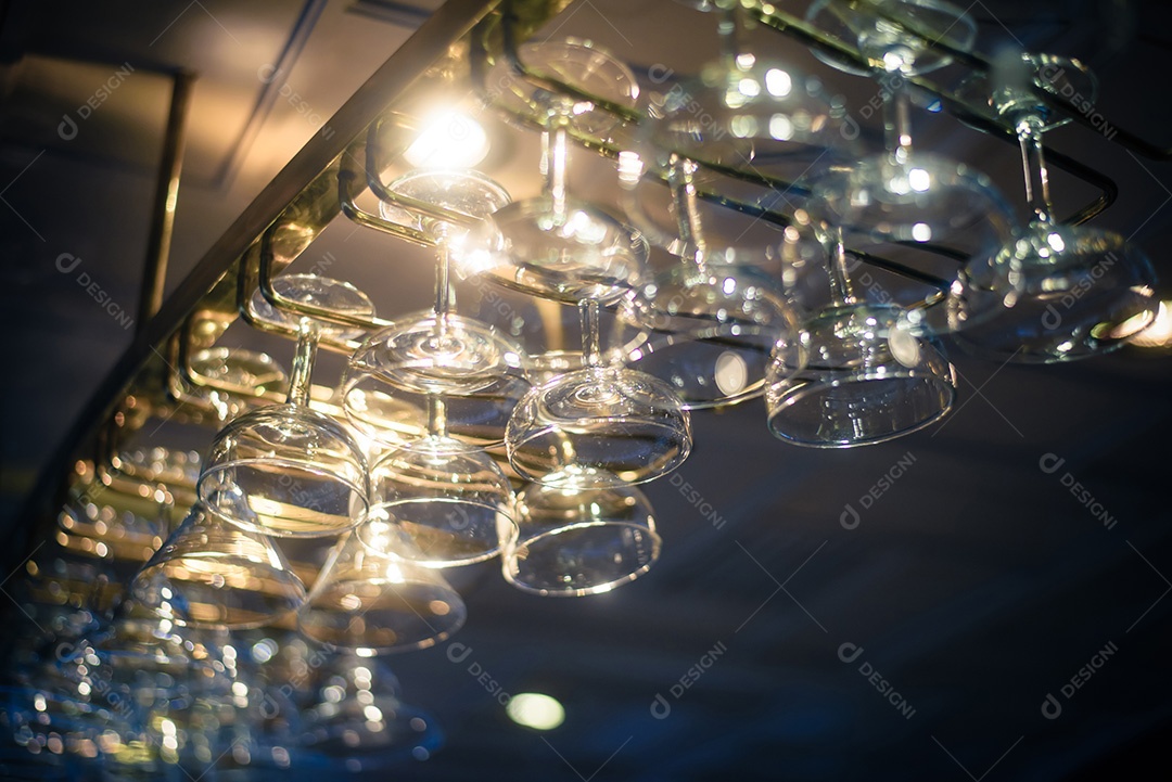 Copos vazios para vinho acima de um rack de bar em tom vintage.