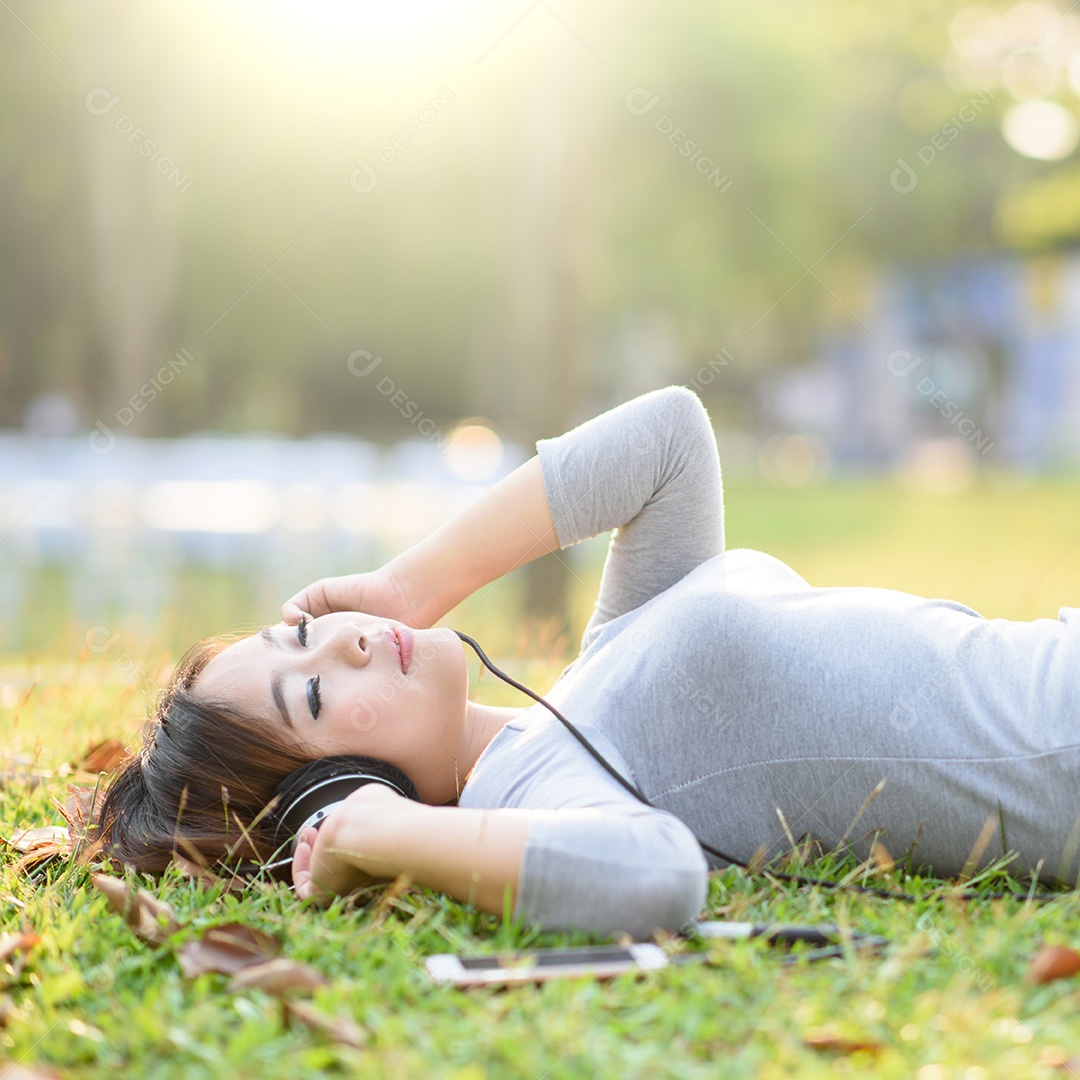 Jovem ouvindo música com fones de ouvido no parque da cidade