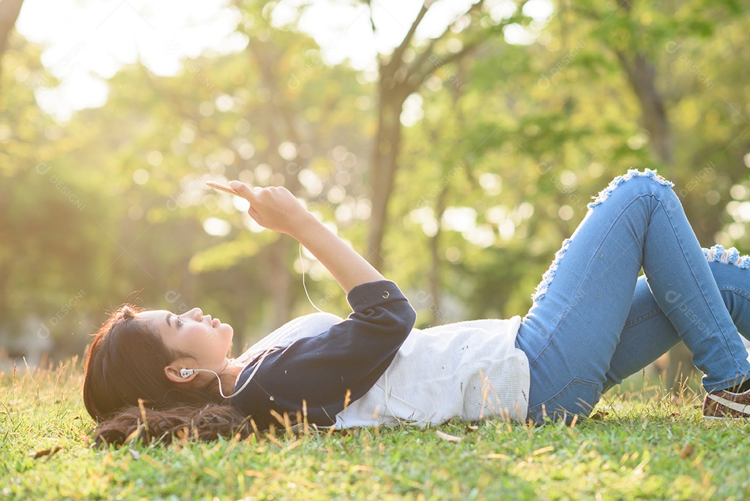 Jovem ouvindo música no parque da cidade