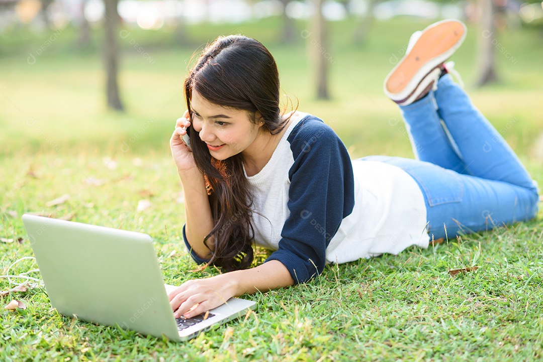 Garota atraente com laptop falando ao telefone