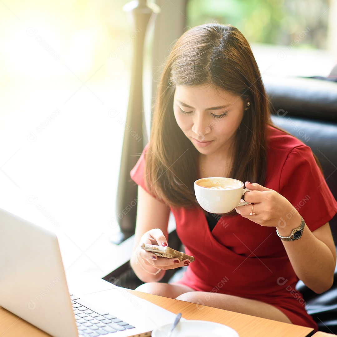 Mulher asiática trabalhando com laptop, celular e café