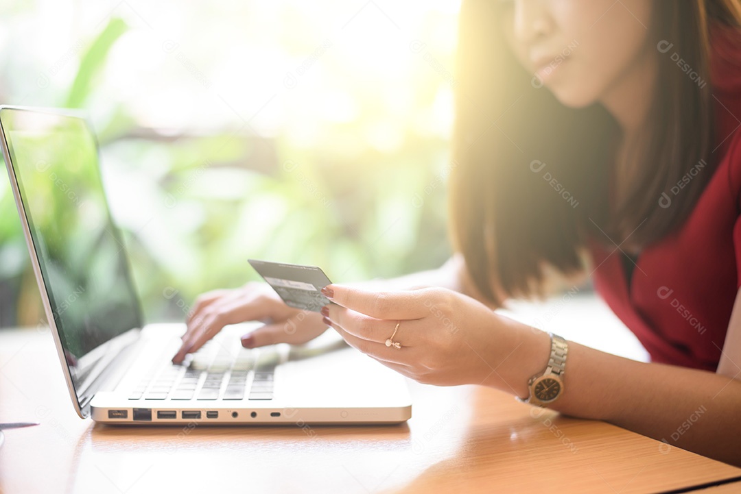 Conceito de comércio eletrônico. Mulher com cartão de crédito, laptop