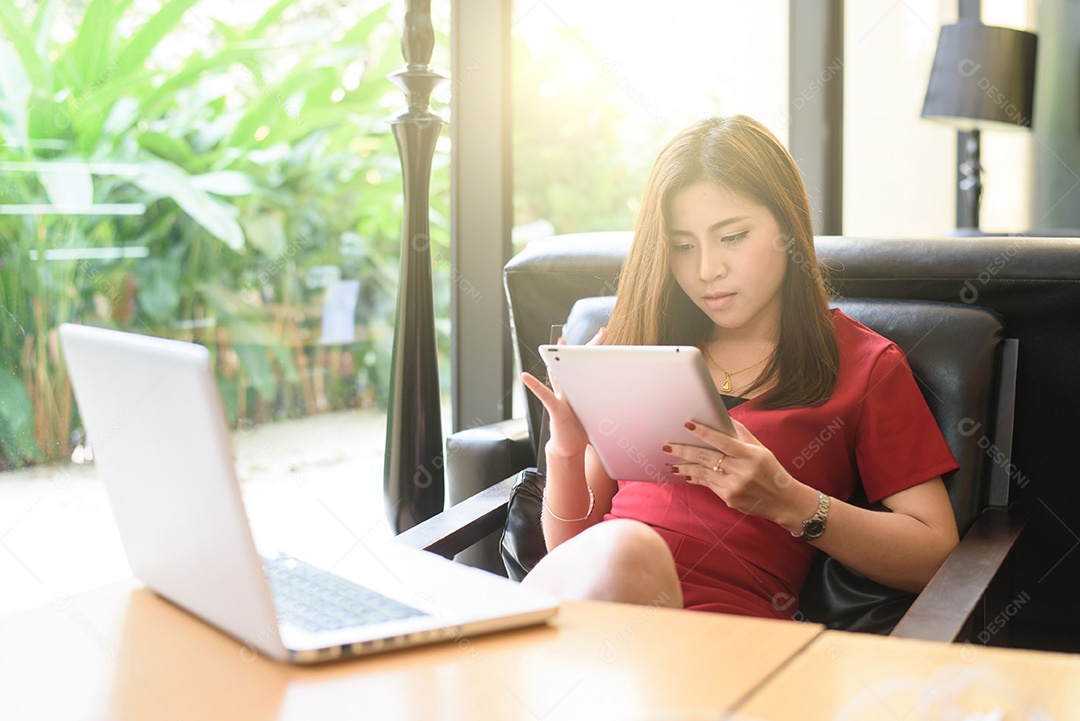 Mulher jovem feliz bebendo café / chá e usando computação tablet