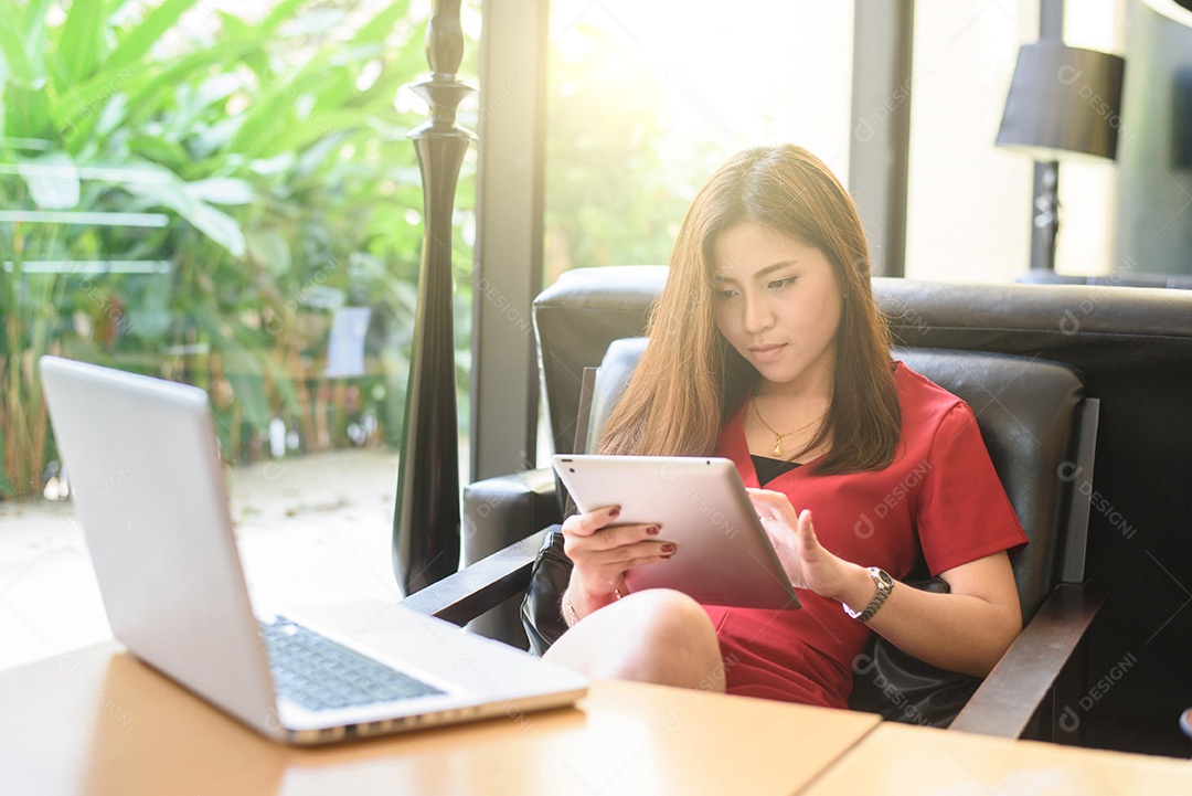 Mulher jovem feliz bebendo café / chá e usando computação tablet
