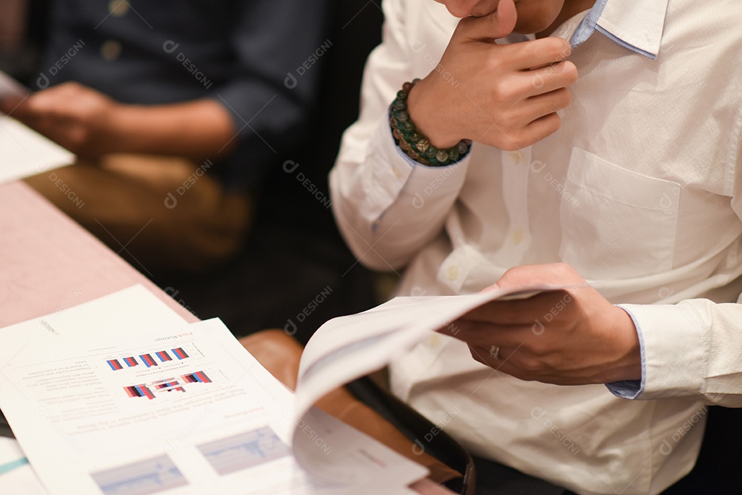 Close-up do empresário segurando o documento na mesa