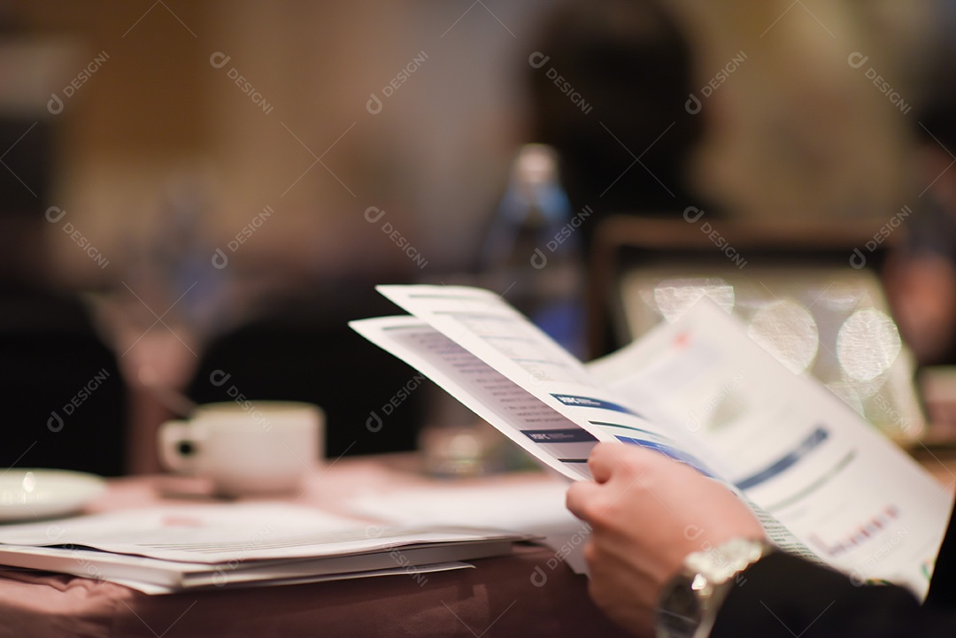 Close-up do empresário segurando o documento na mesa