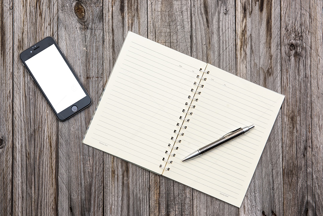 Caderno em branco sobre fundo de textura de madeira.