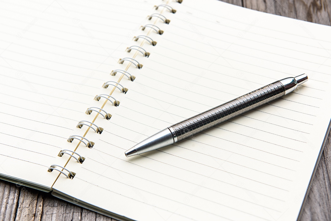 Caderno com a caneta-tinteiro na mesa de madeira