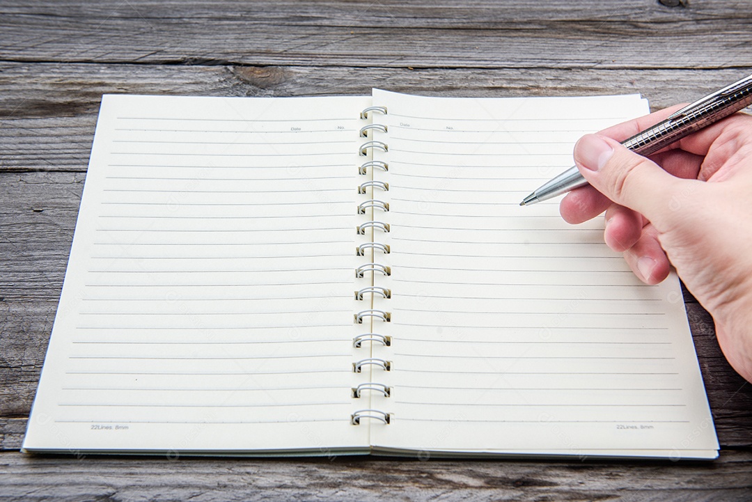 Mão escrevendo no caderno com caneta