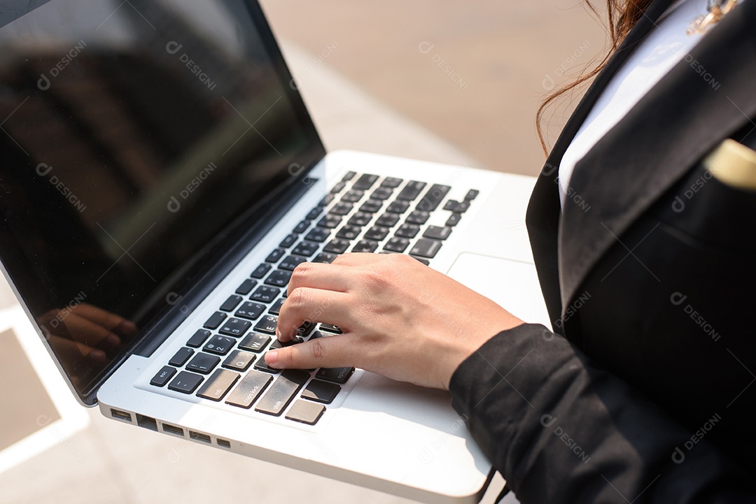 Uma foto da empresária trabalhando em seu laptop