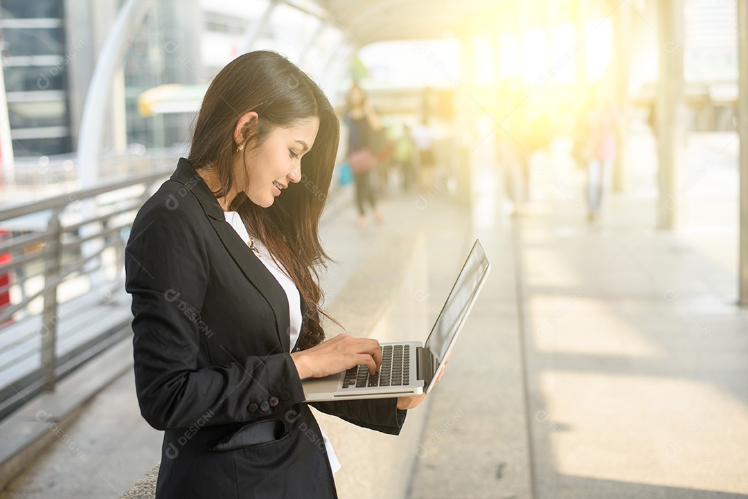 Uma foto da empresária trabalhando em seu laptop ao ar livre