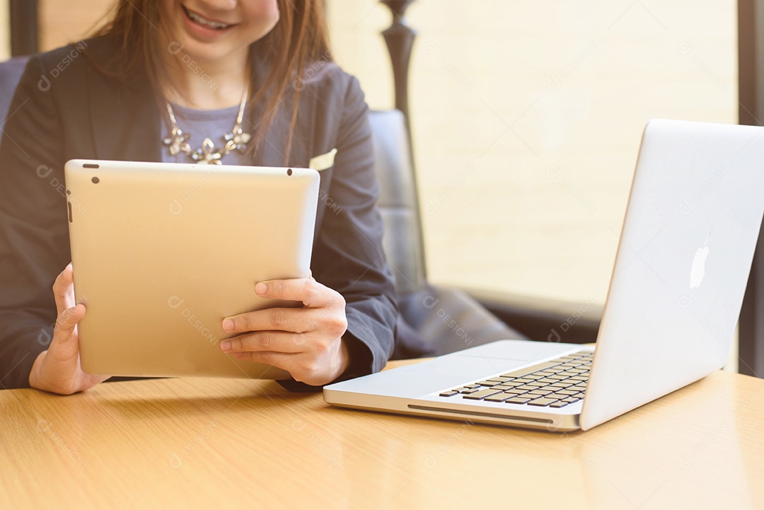 Mulher de negócios usando tablet e laptop