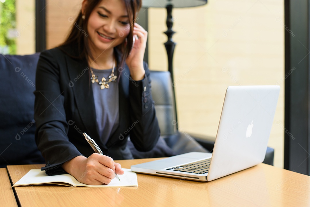 Telefonema de mulher de negócios e escrevendo e usando laptop