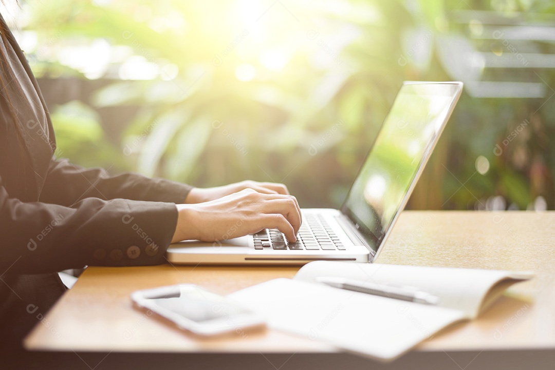 Imagem recortada de uma mulher trabalhando no laptop e escrevendo