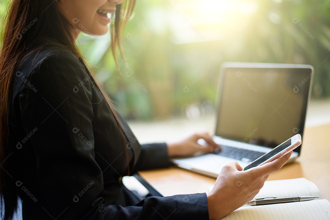 Imagem recortada de uma mulher trabalhando no laptop e escrevendo