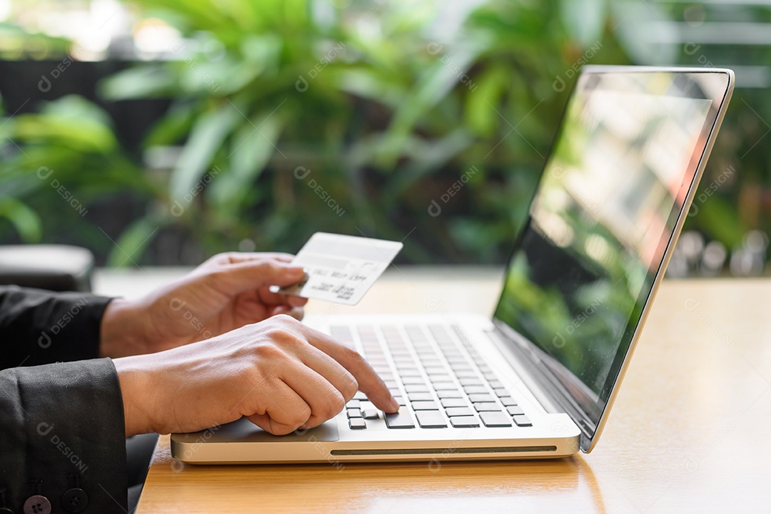 Close-up de uma mulher fazendo compras on-line usando laptop com cartão de crédito