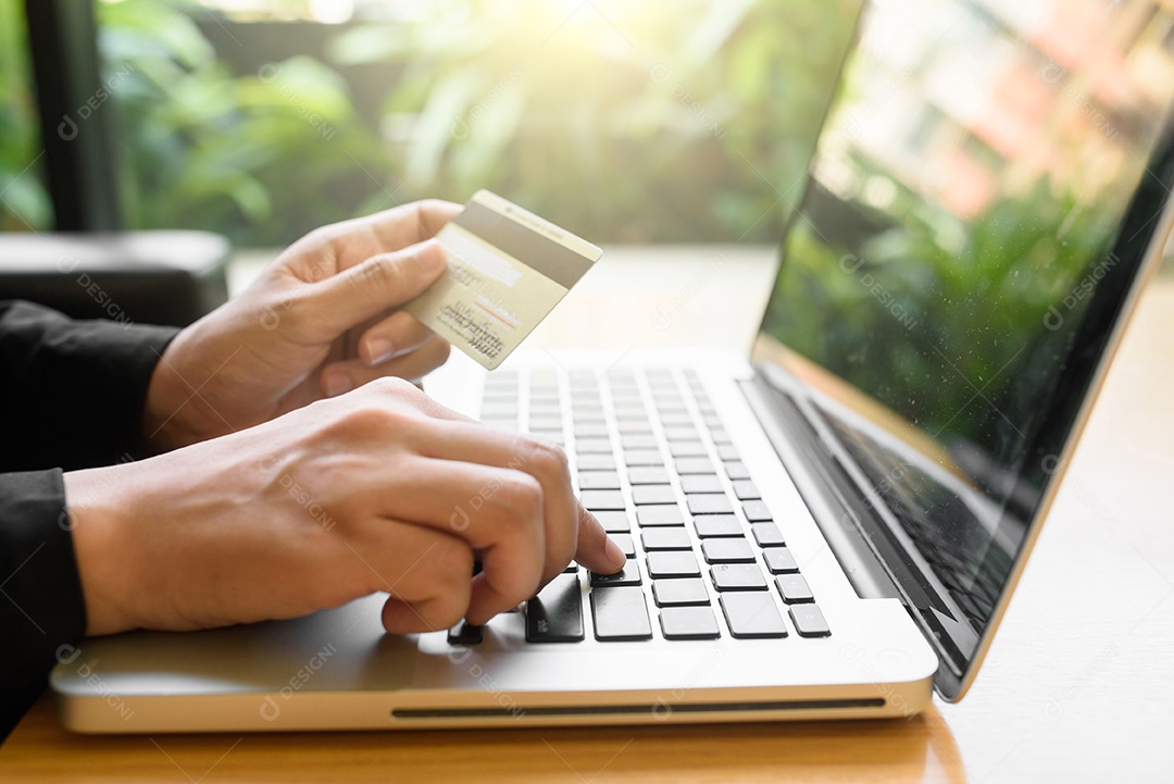 Close-up de uma mulher fazendo compras on-line usando laptop com cartão de crédito