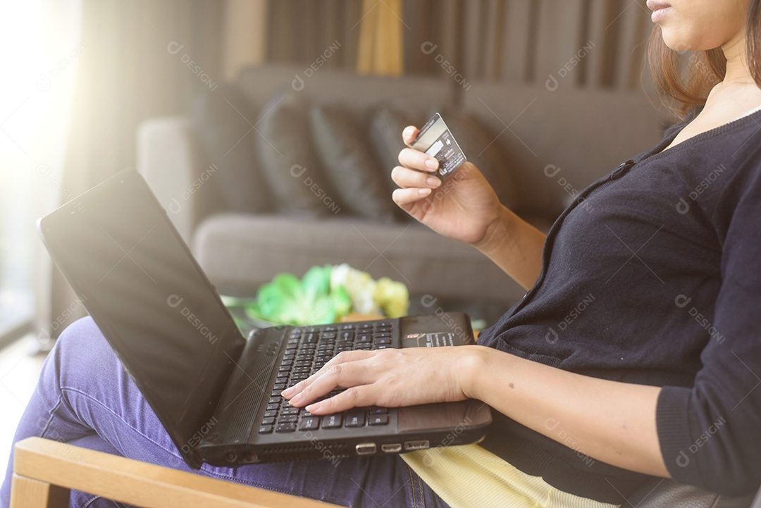 Close-up de uma mulher fazendo compras on-line usando laptop com cartão de crédito