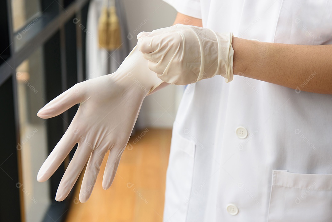 Médico colocando luvas