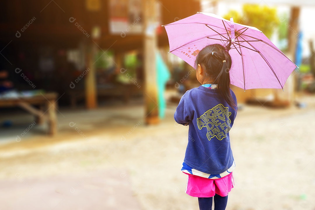 Garota com guarda chuva e olhando para algo em casa.
