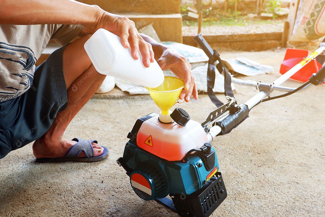Mão do homem é segurar e apertar o botão Para fazer a lâmina de corte do cortador de grama é trabalho