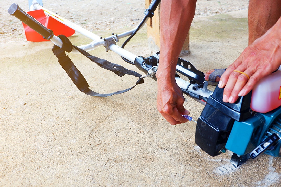 Mão do homem é segurar e apertar o botão Para fazer a lâmina de corte do cortador de grama é trabalho