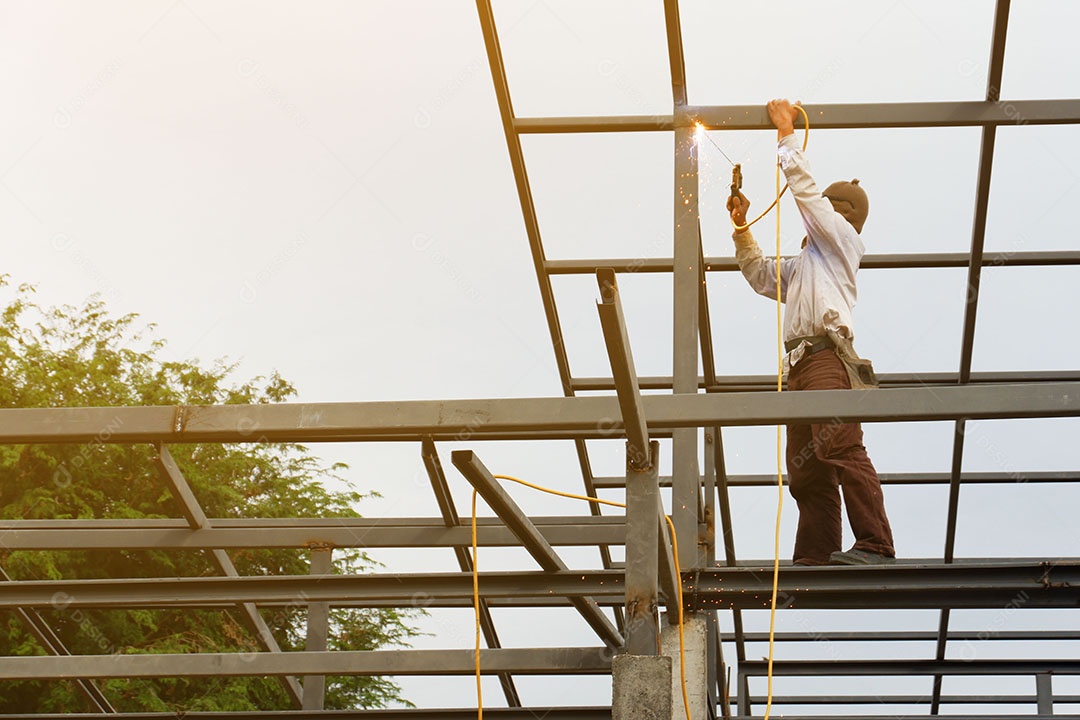 Soldador está soldando a estrutura do telhado da casa.