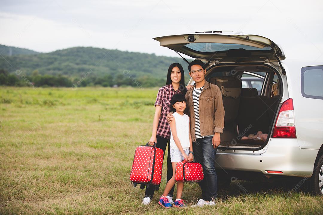 Menina feliz com família asiática sentada no carro para curtir a viagem e as férias de verão na van campista