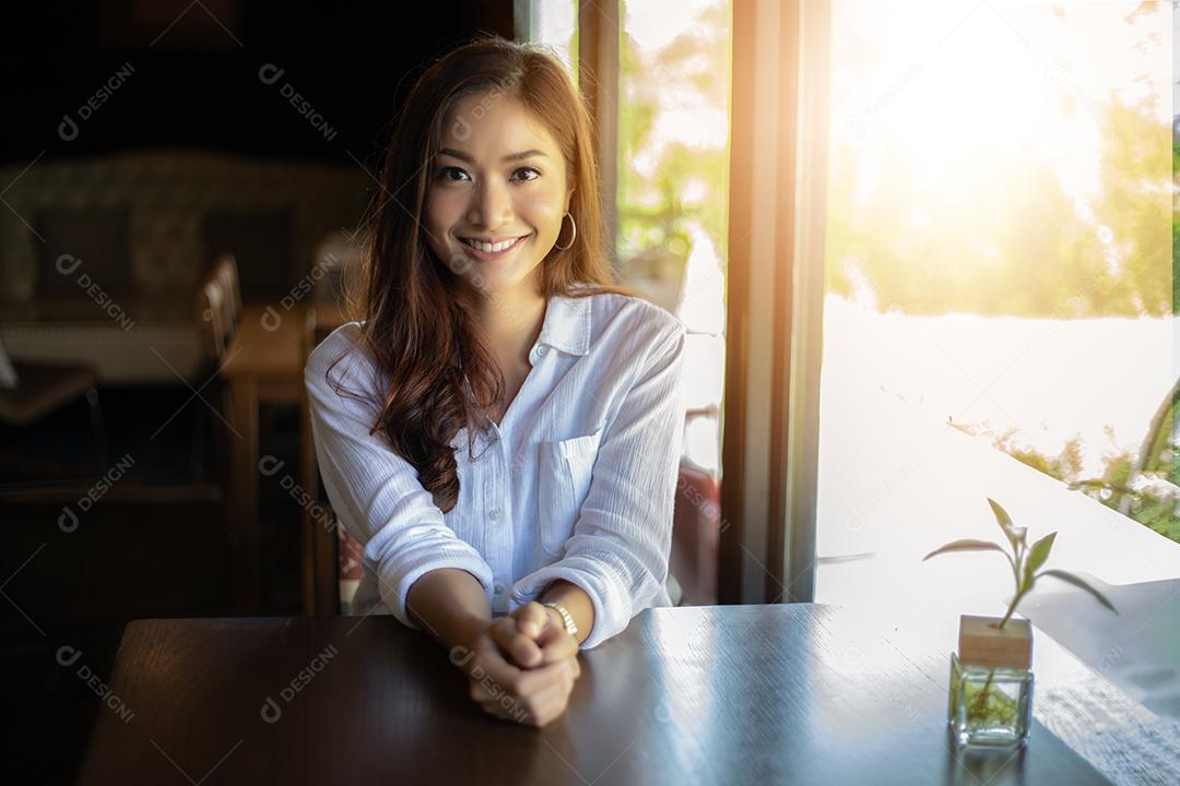 Mulheres asiáticas sorrindo e felizes Relaxando em uma cafeteria depois de trabalhar em um escritório de sucesso.