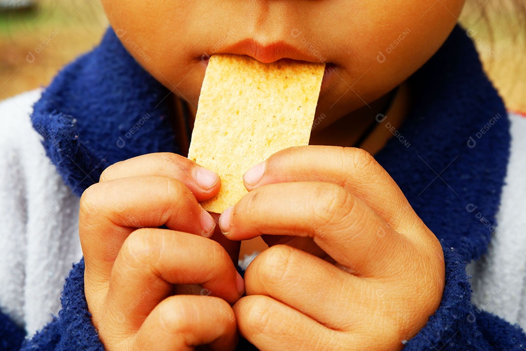 Garota está trazendo um lanche em sua boca.
