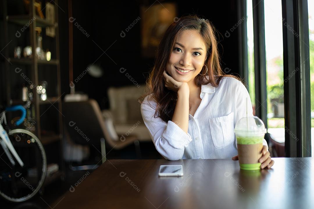 Mulheres asiáticas sorrindo e felizes Relaxando em uma cafeteria depois de trabalhar em um escritório de sucesso.