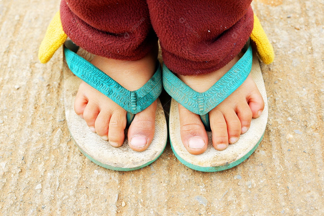Pé de menina quando ela é colocada usando sapato de sandália no inverno na zona rural no norte da Tailândia