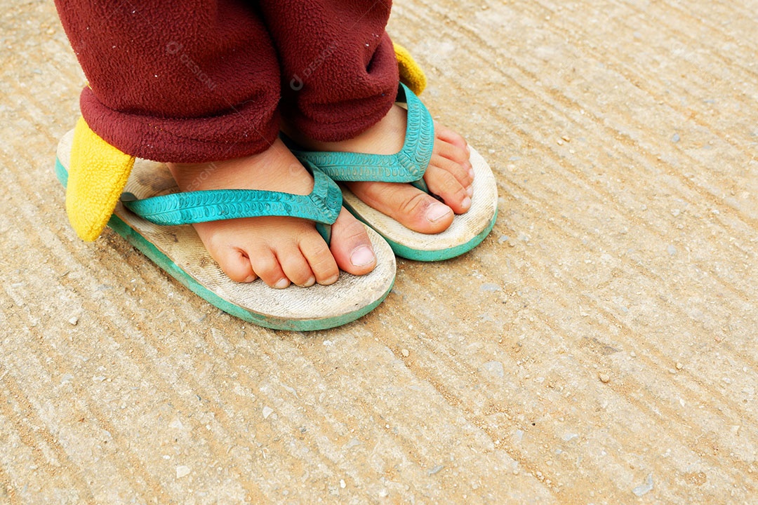 Pé de menina quando ela é colocada usando sapato de sandália no inverno na zona rural no norte da Tailândia