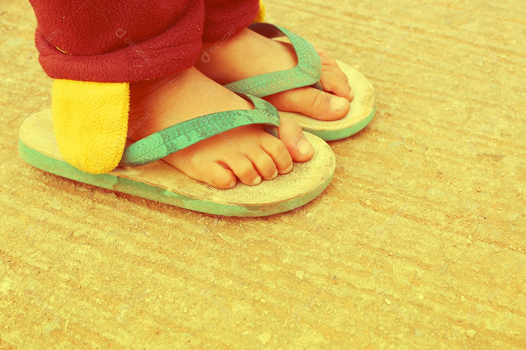 Pé de menina quando ela é colocada usando sapato de sandália no inverno na zona rural no norte da Tailândia