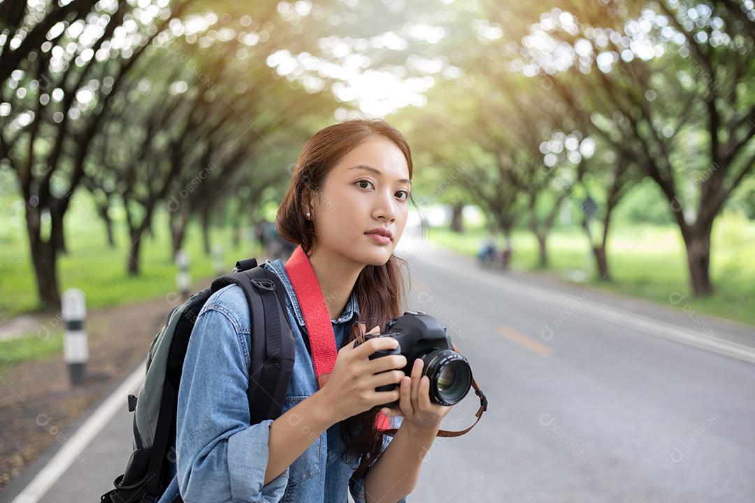 Fotógrafo de mulheres segurando uma câmera em estado selvagem para tirar uma foto do viajante turístico