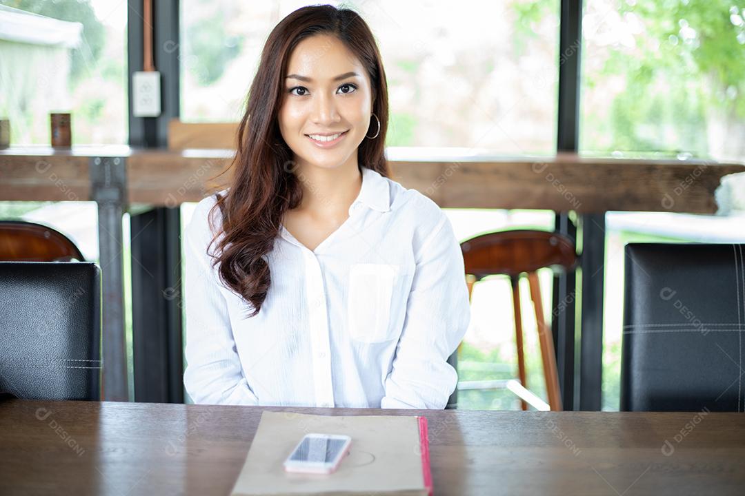 Menu aberto de mulher asiática para pedir no café e restaurante e sorrindo para um momento feliz